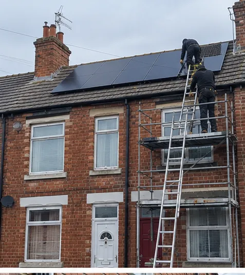 Installers fitting solar PV panels to the roof of a brick terraced home using scaffold access